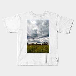 Stormy cloudscape over meadow, Poland, Europe Kids T-Shirt